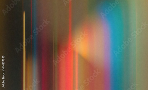 Abstract illustration in a blurry, soft-focus style with vertical light beams. The image features vibrant yellow, orange, red, blue, and green hues, blending together with subtle gradient shapes.
