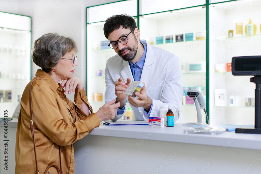 Fototapeta premium Male pharmacist consulting and explaining prescription medication to senior woman client in the pharmacy for pharmaceutical healthcare treatment