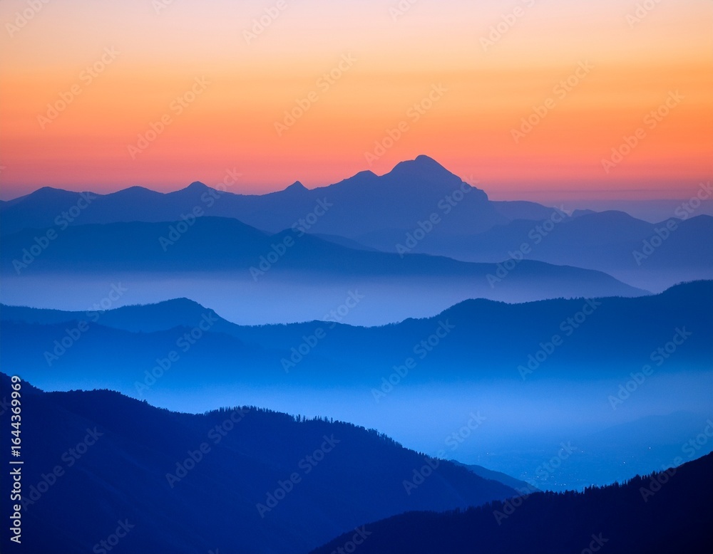 softly glowing peaks of layered blue mountains against a vibrant gradient sky with hues of pink and orange during sunrise on a misty morning orange blue layering softly glowing peaks of layered blue mountains against a vibrant gradient sky with hues of pink and orange during sunrise on a misty morning orange blue layering