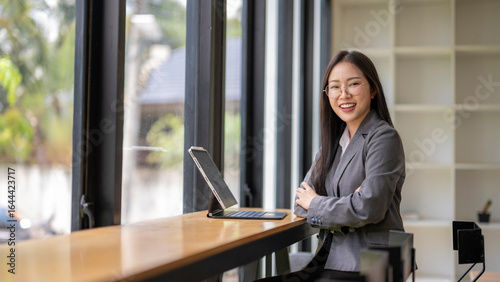 Smiling businesswoman working with tablet in modern office space Free Download Smiling businesswoman working with tablet in modern office space - GFXLoad