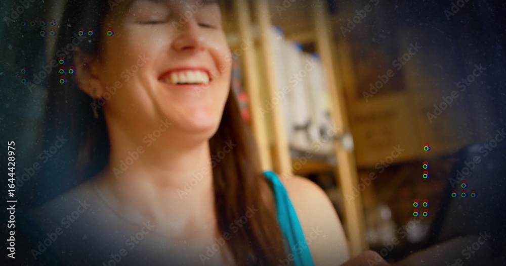 Smiling adult woman interacting with smartphone in home office with shelves and books, soft light Smiling adult woman interacting with smartphone in home office with shelves and books, soft light