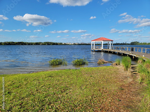 Gazebo - Lake Baldwin Park in Orlando, Winter Park, Florida, USA. Lake view landscape with red gazebo. Ecological Park for visitors on a travel vacation in Orlando, Florida, USA.