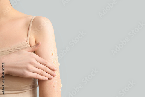 Wallpaper Mural Young woman applying natural scrub onto her shoulder against grey background, closeup Torontodigital.ca