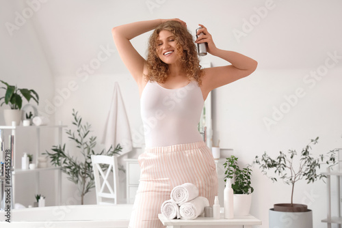 Happy young woman applying ...