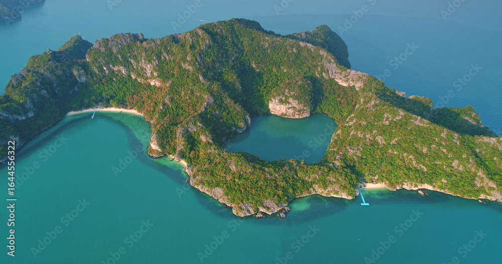 Fototapeta premium Breathtaking aerial view revealing Mae Ko island in Ang Thong National Marine Park, Thailand, featuring lush vegetation, a hidden lagoon, and vibrant turquoise waters