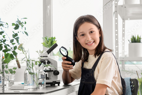 Child education and science learning, young girl with magnifying glass in sch...