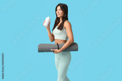 Sporty young woman with yog...