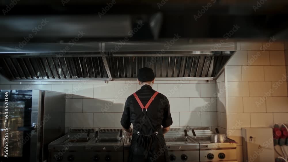 sous chef in uniform approaches the frying ovens sous chef in uniform approaches the frying ovens