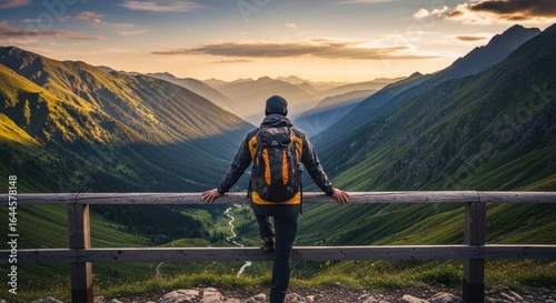 Hiker's Serene Pause Overlooking a Sun-Kissed Alpine Valley at Dawn