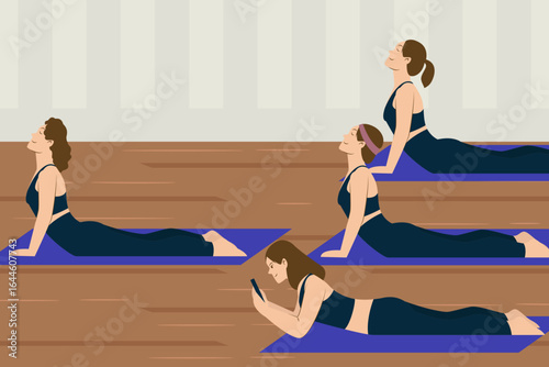 Women practicing yoga poses indoors with one person distracted using a smartphone on a mat.
