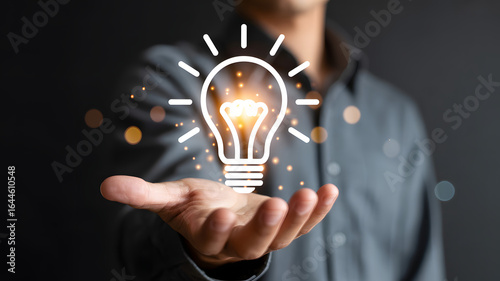 Man holding glowing lightbulb in hand symbolizing innovation and new ideas
