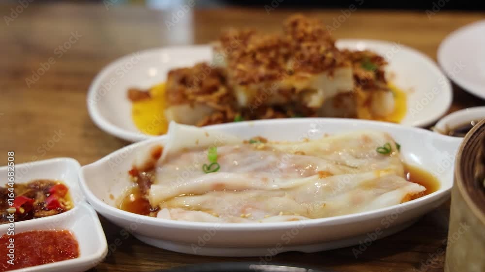 Chopsticks Lifting Steamed Rice Noodle Rolls at Restaurant Table Chopsticks Lifting Steamed Rice Noodle Rolls at Restaurant Table