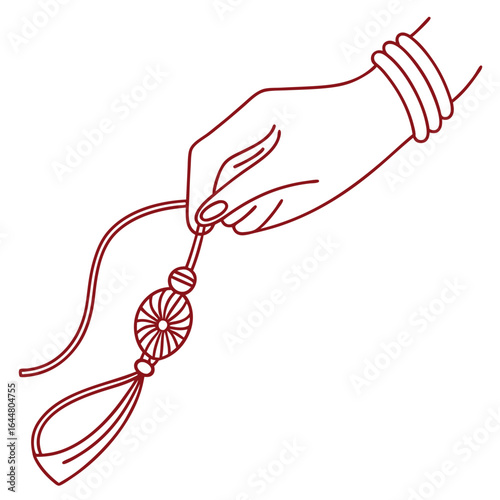 A delicate hand adorned with bangles holds a traditional rakhi with a decorative bead and tassel symbolizing sibling love and protection during raksha bandhan celebrations