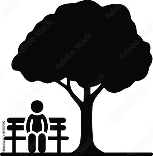 Single person sitting on park bench under a large tree silhouette