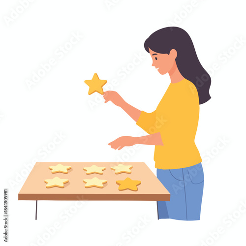 A woman carefully places a star-shaped cookie onto a baking sheet filled with similar cookies.