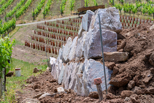 Chantier en cours : les premières pierres d'un mur de soutien dans le vignoble en terrasse sur les coteaux alsaciens