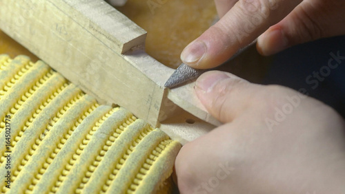 Obraz na plátně Skilled luthier carefully rasping wooden instrument part, revealing intricate ha