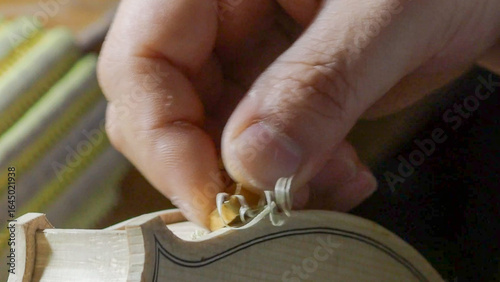 Fotografie Skilled luthier meticulously carving wooden violin parts, highlighting intricate
