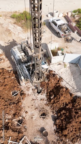 Wallpaper Mural Sa'ar, Israel - 28 July 2025: Aerial view of a towering drilling rig amidst a construction site, contrasting against the surrounding raw earth and parked vehicles. Torontodigital.ca