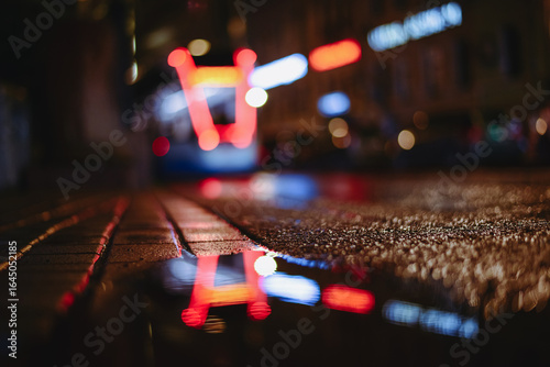 Wallpaper Mural Europe. Night city. A illuminated tram is reflected in puddles. Beautiful atmospheric night city background with background blur. High quality photo Torontodigital.ca
