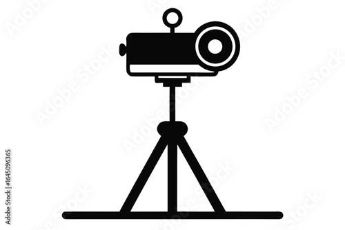 Black movie projector sits upon the tripod stand on a white backdrop neatly