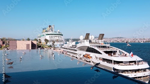 Aerial view of huge snow-white passenger liners docked in port of Istanbul. Seagulls and reflection in water on summer evening, Istanbul, Turkey. High quality 4k footage