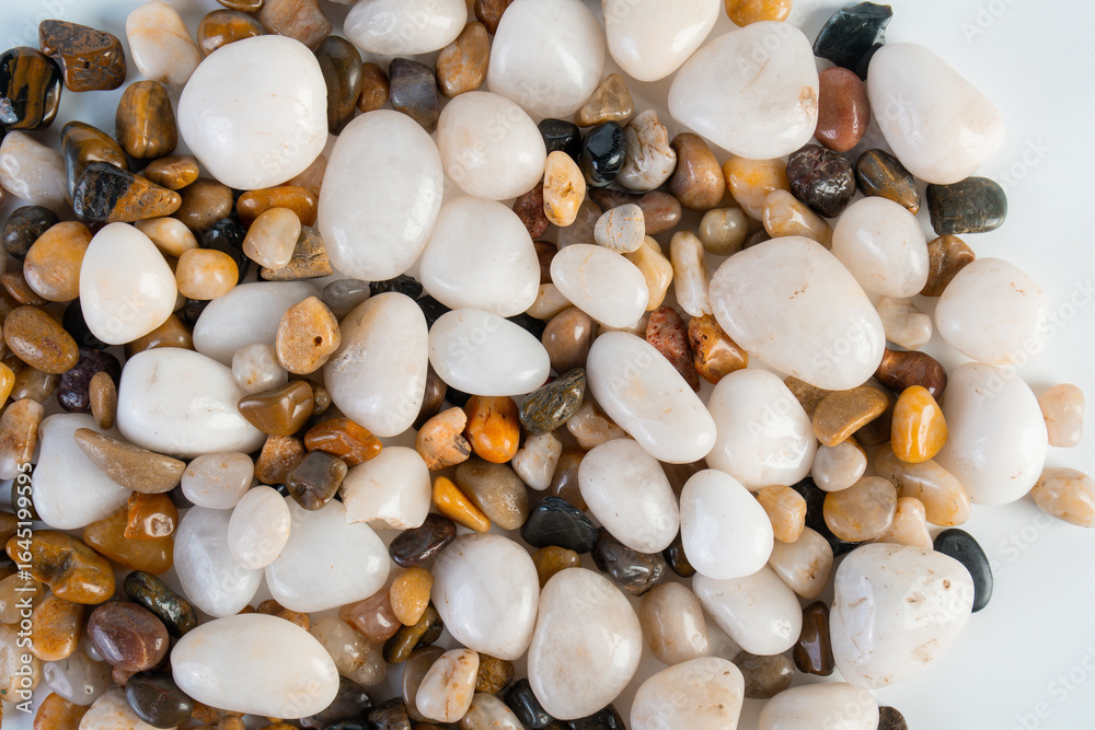 Obraz premium A variety of small stones of different geological origins on white background.