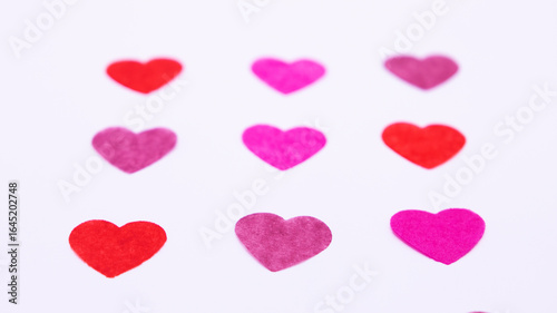 nine colored paper hearts on a white background