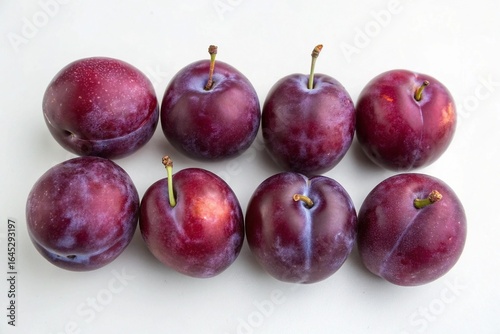 Fresh ripe plums arranged on a white background