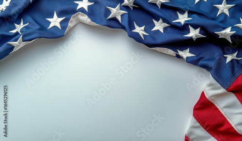 Waving American Flag Draped on a Light Surface Showcasing Red, White, and Blu...