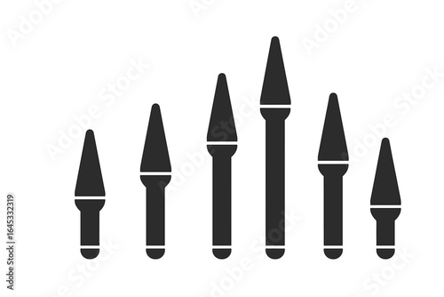 Different sizes of pointed tools arranged in order of length against a plain background