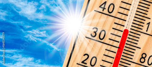 Photos Ein Thermometer zeigt hohe Temperatur vor strahlender Sonne - FOTOMONTAGE