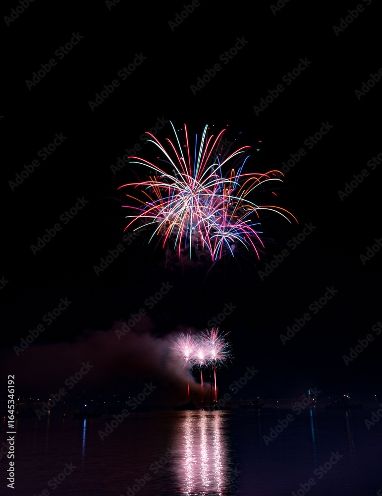 Vibrant fireworks over a lake at night. Vibrant fireworks over a lake at night.