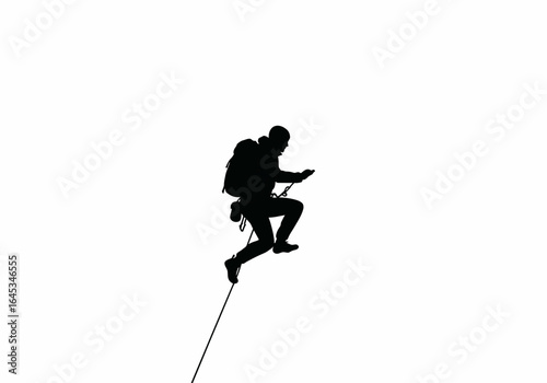 Silhouette of a Climber Rappelling Down a Rope