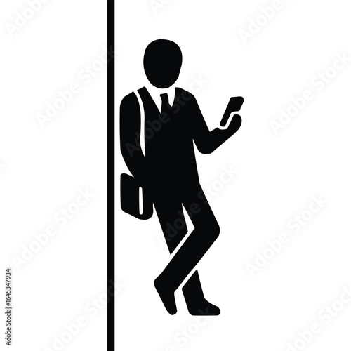 Man in suit with briefcase leaning against a pole while looking at his smartphone silhouette