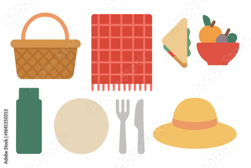 Outdoor picnic setup with a basket, blanket, sandwich, and fruits in a vibrant arrangement on a sunny day