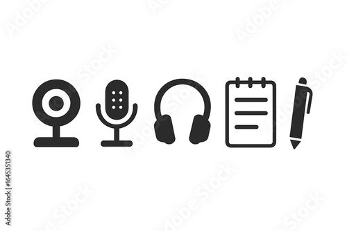 Equipment for podcasting or audio recording setup with webcam, microphone, headphones, notes, and pen