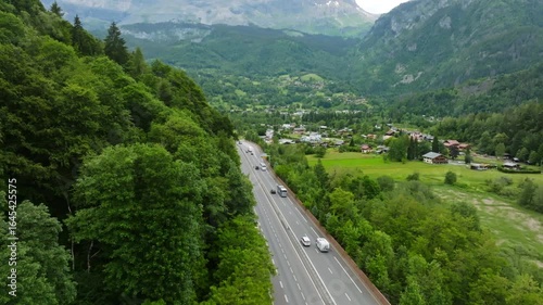 Aerial ascending shot of traffic on road N205 and the Servoz town, in France