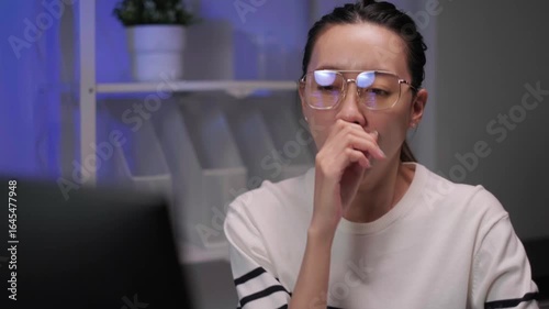 Close-up businesswoman using laptop computer sleepy searching information working overtime serious fatigue burnout unhappy employee