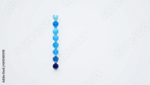 Gradient blue spheres lined up on white background

