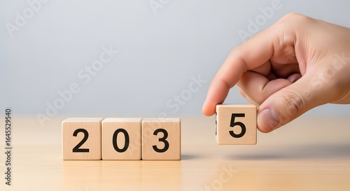Hand changing wooden blocks for year two thousand thirty five future goal planning concept