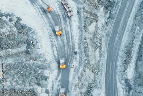 top-down view of mining trucks driving along the road inside an