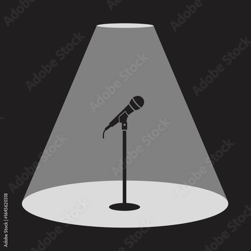 A microphone on a stand illuminated by a spotlight.