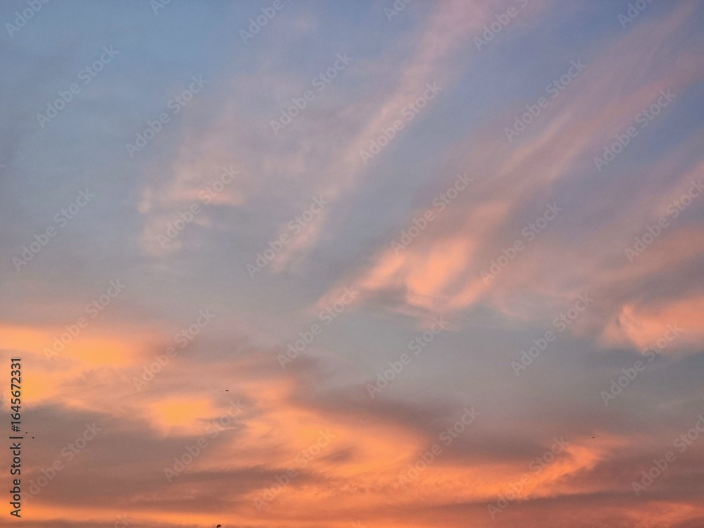 Fototapeta premium Peaceful evening sky with soft orange clouds during sunset