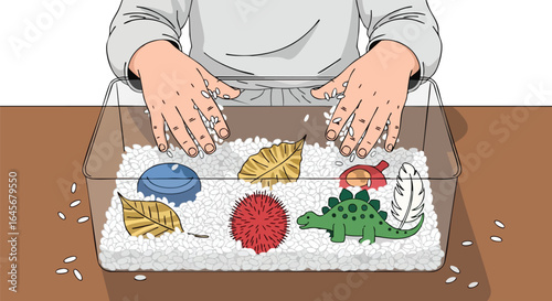 Childs hands exploring a sensory bin with rice and toys.