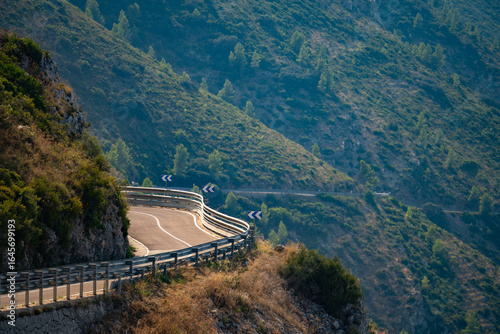 Winding mountain road with guard rails and directional signs