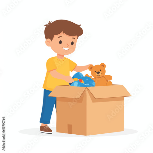 Boy putting toys into a cardboard box, including a teddy bear and a blue toy.