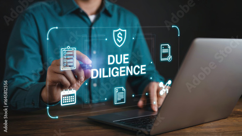 Man using laptop to analyze Due Diligence data with modern digital interface