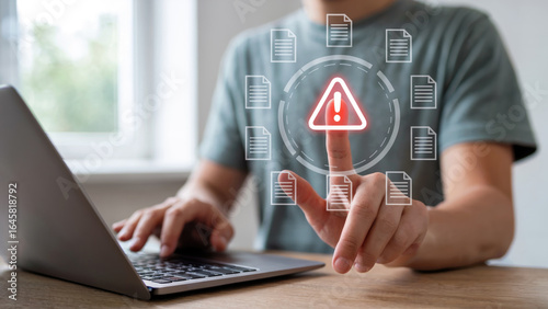 Man pointing at data breach alert with laptop, highlighting security risk and digital threats