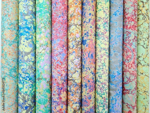 Collection of colorful handmade marbled paper rolls